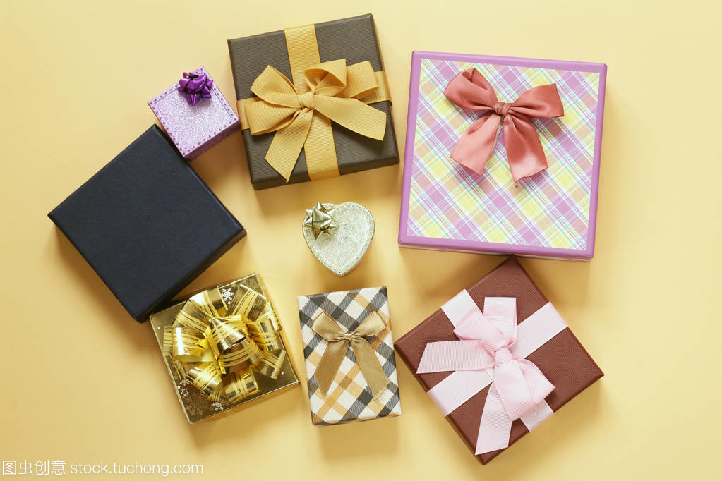 大量的米色背景上蝴蝶结的礼品盒